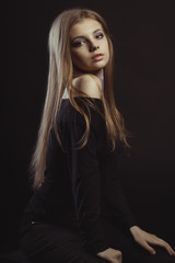 Fototapeta na wymiar Beautiful young woman with long blonde hair on a black background