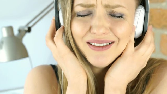 Sad girl crying while listening music and looking to the camera, steadycam shot
