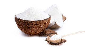 ripe organic coconut with sweet shavings with wooden spoon isolated on white