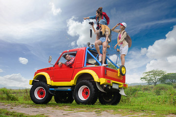 woman and man are traveling in group on the convertible car at field of lake