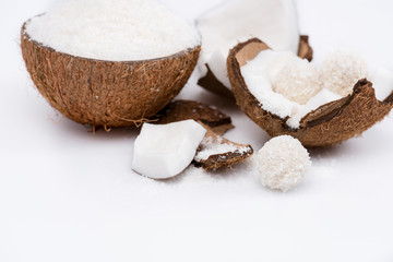 Fototapeta na wymiar Close-up view of ripe coconut with shavings and sweet tasty candies isolated on white
