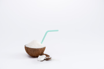 Close-up view of half of tasty coconut with shavings and straw isolated on white