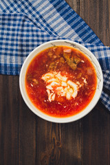 Traditional Ukrainian Russian vegetable borscht on the white wooden background. Top view