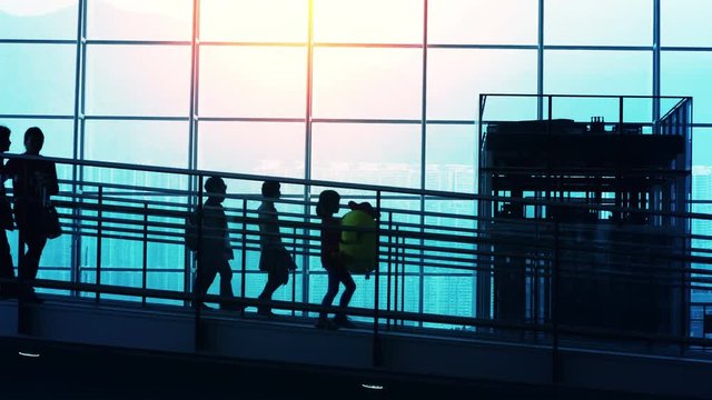 Sunset Silhouettes of Commuter in Airport.
Sunset airport terminal hall. Walking travelers silhouettes.
