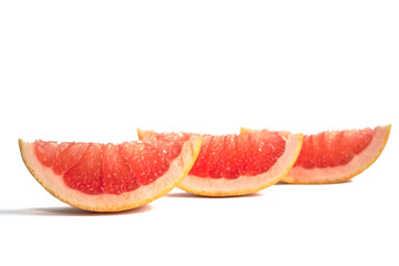 Closeup of grapefruit wedges on a white background