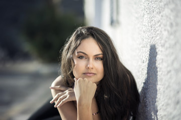 Beautiful young brunette woman looking up leaning on her hands