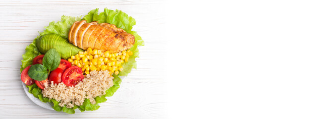 Buddha bowl. Healthy dinner with quinoa, chicken, tomatoes, avocado, spinach and lettuce leaves.  Healthy salad bowl on white background. Long web format. Top view