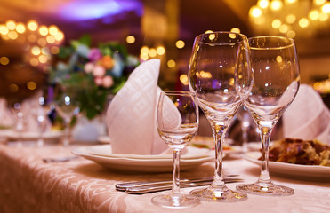 Sparkling glassware stands on long table prepared for wedding dinner

