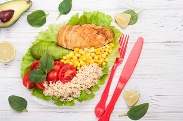Buddha bowl. Healthy dinner with quinoa, chicken, tomatoes, avocado, spinach and lettuce leaves.  Healthy salad bowl on white background. Top view