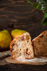 Freshly baked homemade cake with pear and raisin sprinkled with powdered sugar on a wooden background, rustic style.