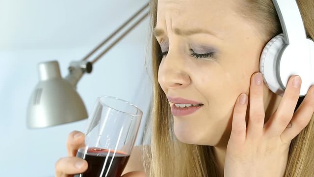Sad girl crying while listening music and drinking wine, steadycam shot
