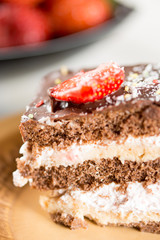 Closeup macro slice of chocolate cake with strawberries on the p