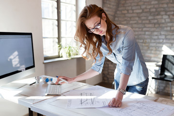 Female designer in office working on architects project