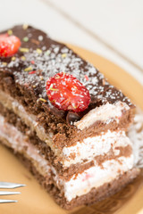 Closeup macro slice of chocolate cake with strawberries on the p