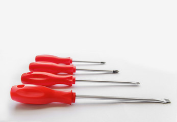Four red shiny metal and plastic tool screwdriver for repair
