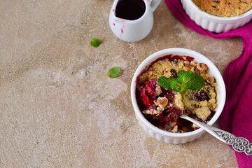 Crumble with berries, oatmeal and nuts on a concrete background