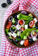 Classic Greek salad with sauce on a metal, grunge background. Greek cuisine.