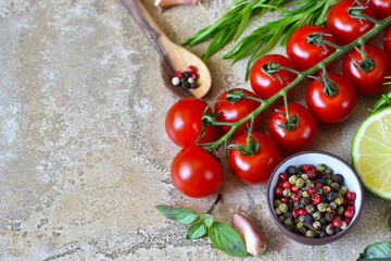 Food background with different ingredients on a marble background. Cherry tomatoes, rosemary, garlic, pepper, lime. Top view.