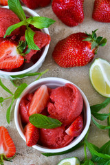 Summer dessert. Strawberry, cold sorbet with mint and ice on a concrete background.