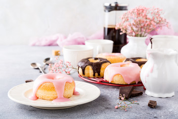 Homemade doughnuts with pink glaze on light gray background. Selective focus. Copy space.
