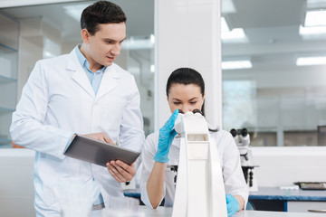 Attentive female scientist examining DNA chain
