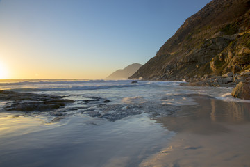 Tidal movement at Noordhoek Beach on the Cape Peninsula in South Africa, against the backdrop of the Cape Peninsula mountains.