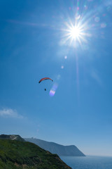 Paraglider flying against the blue sky