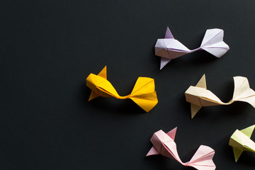 Handmade paper craft origami gold koi carp fishes on black background.Top view, pattern - obrazy, fototapety, plakaty