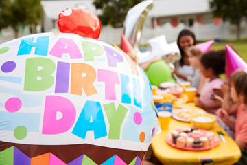 Mother With Children Enjoying Outdoor Birthday Party Together