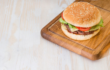 Tasty burger on a wooden background copyspace