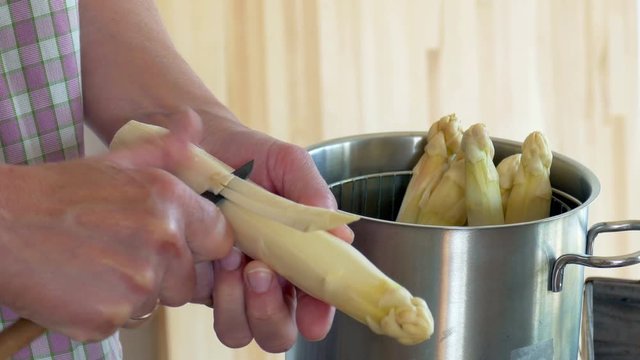 Peel asparagus - woman is peeling asparagus