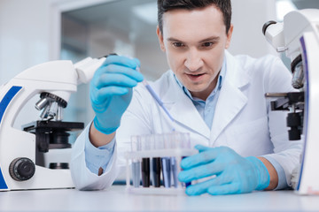 Enigmatical scientist doing reagent examination