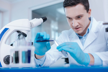 Portrait of serious medical worker while inventing new reagent