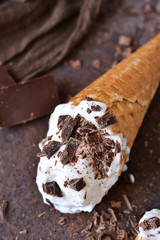 Vanilla ice cream cone with chocolate on an old grunge background
