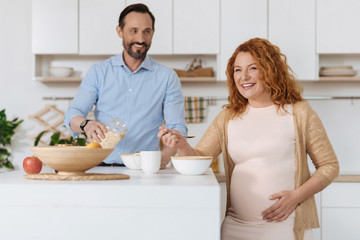 Obraz na płótnie Canvas Cheerful married couple having breakfast at home