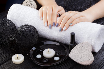 beautiful gray manicure with towel on the white wooden table. spa