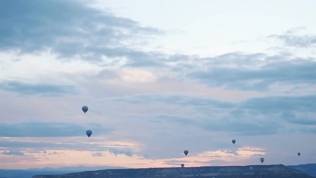 Hot air balloon flying over rock landscape at Cappadocia Turkey. Cappadocia with its valley, ravine, hills, located between the volcanic mountains in Goreme National Park.