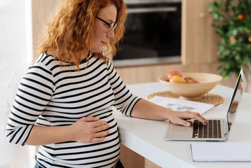 Curly-haired future mom working from home