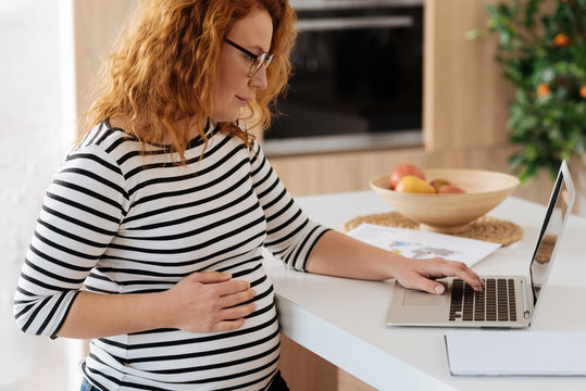Curly-haired future mom working from home