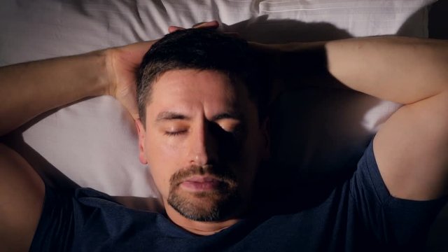 The depressed man in bed. Close-up. 4K.