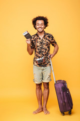 Happy man holding passport and suitcase.