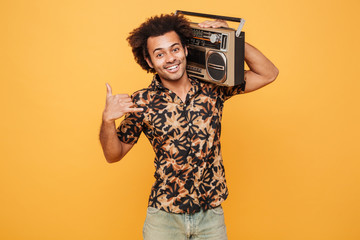 Man in summer clothes holding boombox on his shoulder