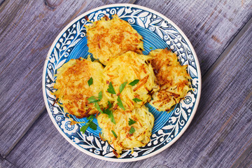 Potato Pancakes With Yogurt Sauce. Vegetable fritters. Latkes on blue plate. View from above