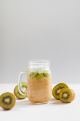 Fresh healthy fruit smoothies from kiwi, banana, pear and apple in a jar on a white background. Soft focus. Vegetarian food