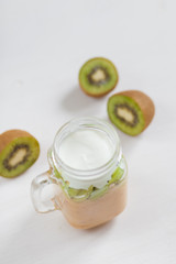 Obraz na płótnie Canvas Fresh healthy fruit smoothies from kiwi, banana, pear and apple in a jar on a white background. Soft focus. Vegetarian food