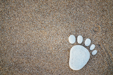 Nice stone made footprint on the sand shore, background.