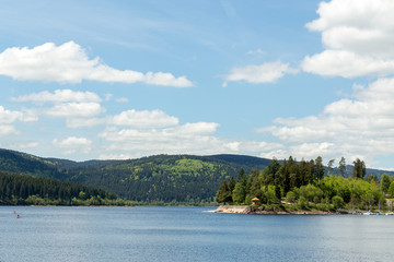 Fototapeta na wymiar Small german lake with blue sky in the black forest
