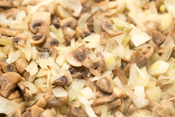 Mushrooms with onions are fried in a frying pan