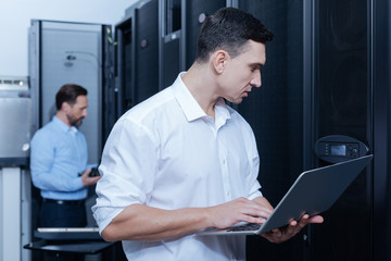 Handsome young technician looking at the control panel