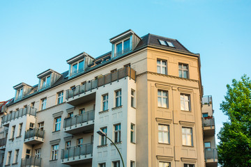Fototapeta premium yellow and white corner house with big balconies
